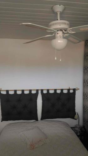 - un ventilateur de plafond dans une chambre avec un lit dans l'établissement Le Miami, à Port-la-Nouvelle