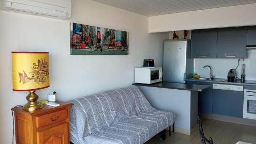 - une cuisine avec un canapé et une table dans une chambre dans l'établissement Le Miami, à Port-la-Nouvelle