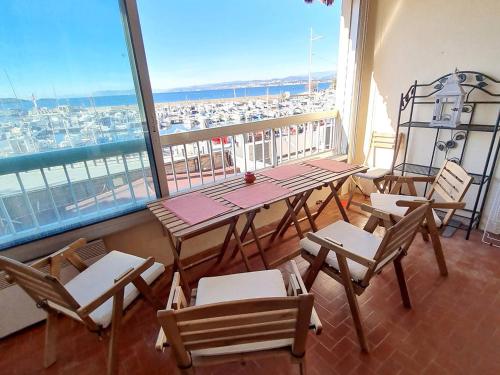 d'un balcon avec des tables et des chaises et une vue sur le port. dans l'établissement T3 climatisé avec Wi-Fi et parking privé - À 200 m de la plage - FR-1-316-316, à Six-Fours-les-Plages