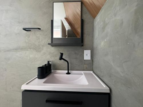 a bathroom sink with a faucet and a mirror at Cabana Pitomba - Viagem Inspirada in Fernando de Noronha
