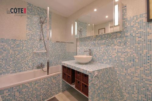 une salle de bain carrelée bleue avec un lavabo et une baignoire dans l'établissement Villa La Largado - 8 couchages, à Sausset-les-Pins