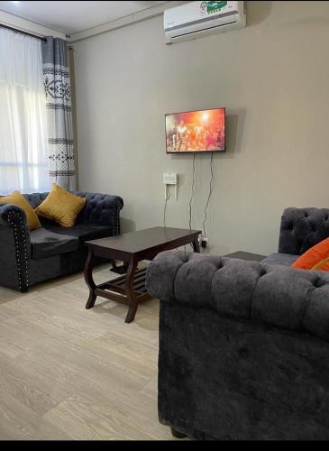 Vipingo Nomadic Apartment في Tezo: غرفة معيشة مع أريكة وطاولة