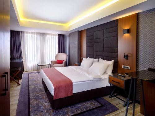 Habitación de hotel con cama y silla en Nova Vista Deluxe & Suites a Member of Radisson Individuals en Eskisehir