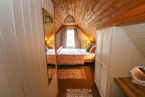Habitación pequeña con 2 camas y ventana en Aggrafard, en Glentrasna