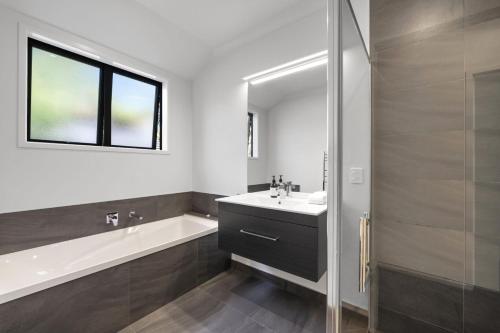 a bathroom with a tub and a sink and a shower at Havelock Holiday House in Havelock North