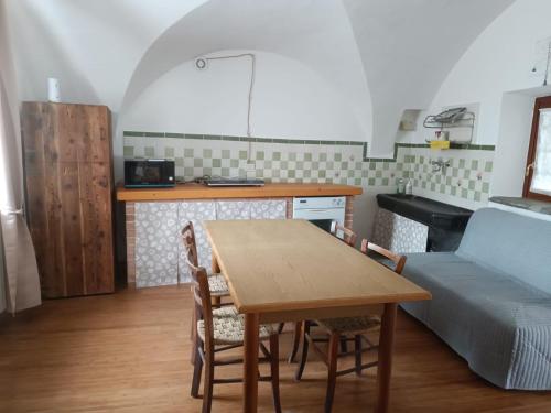 a kitchen and dining room with a table and a couch at Casa di Alvise in Lauco