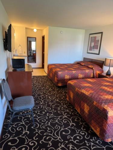 a hotel room with two beds and a television at Malibu Inn in Wisconsin Dells