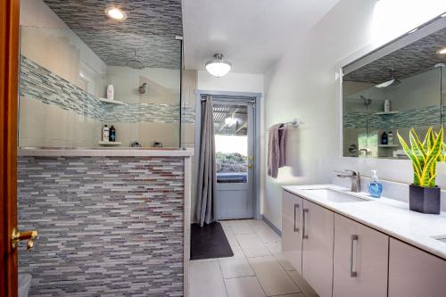uma casa de banho com uma cabina de duche ao nível do chão e um lavatório. em Contemporary River House close to SNP gate -7acres em Three Rivers