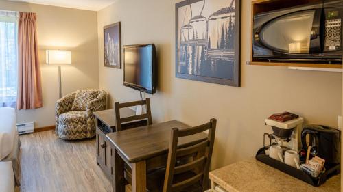 sala de estar con mesa y TV en la pared en Cahilty #355 home en Sun Peaks