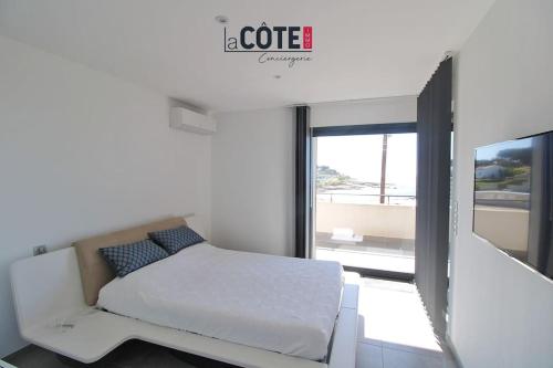 een witte slaapkamer met een bed en een raam bij Villa Maïa - 4 Couchages in Sausset-les-Pins