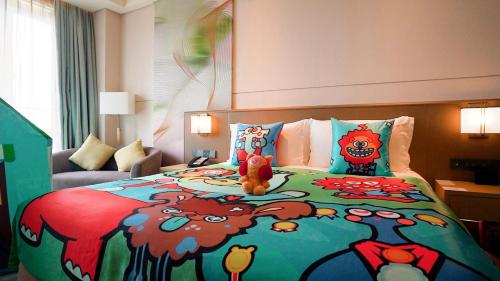 a bedroom with a bed with a teddy bear on it at Holiday Inn Shunde by IHG in Shunde