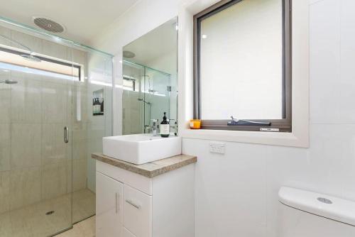 y baño blanco con lavabo y ducha. en Hopkins View Holiday Home, en Warrnambool