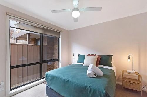瓦南布爾的住宿－Hopkins View Holiday Home，一间卧室设有一张绿色的床和一个窗户。