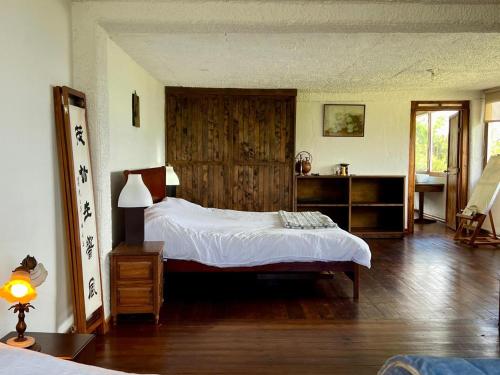 a bedroom with a bed and a wooden floor at Villa cuatro pisos el tramonto in Guatavita
