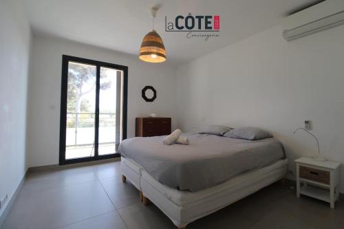 une chambre blanche avec un lit et une fenêtre dans l'établissement Villa Palazzo - 6 couchages, à Sausset-les-Pins