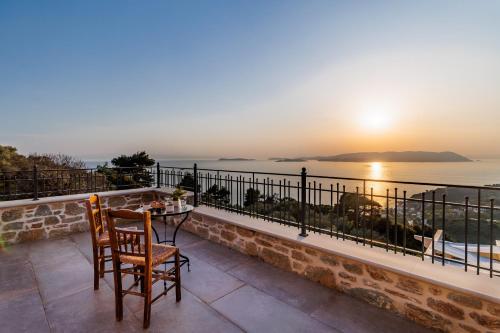 a table and chairs on a balcony with a view of the ocean at RODON Luxury Villas in Skopelos Town