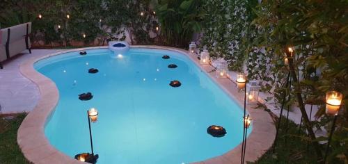 Nassali - Beautiful Villa in Tamaris في الدار البيضاء: حمام سباحة مع أضواء في الفناء الخلفي في الليل