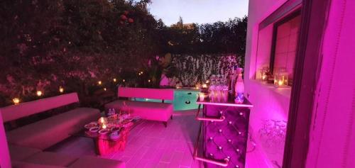 Cette chambre violette comprend un canapé et une table. dans l'établissement Nassali - Beautiful Villa in Tamaris, à Casablanca