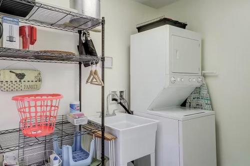 a laundry room with a sink and a refrigerator at Firefly Cottage in Edisto Beach