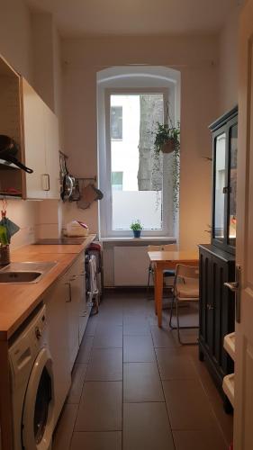 a kitchen with a washing machine and a window at Cozy room in Neukölln , Kreuzberg in Berlin