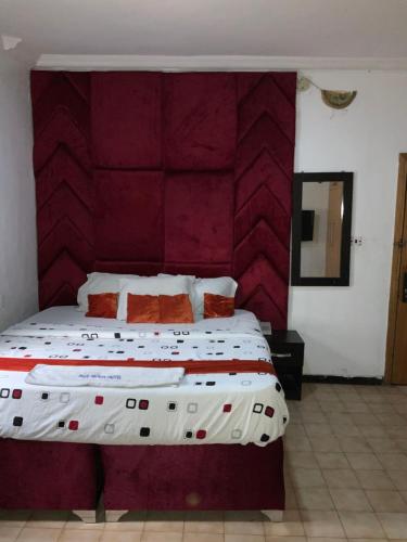 a bedroom with a large bed with a red headboard at BLUE MOON HOTELS VICTORIA ISLAND in Lagos