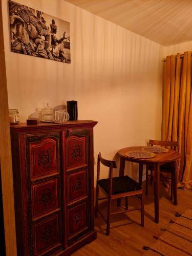 d'une salle à manger avec une table et une armoire en bois. dans l'établissement Home Gãyatri, à Angé