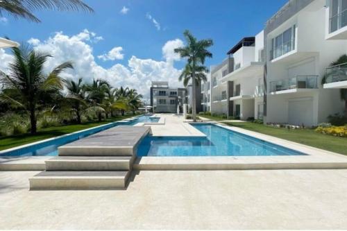 a swimming pool in front of a building at Pool view peaceful 1 bedroom @ Hard Rock in Punta Cana