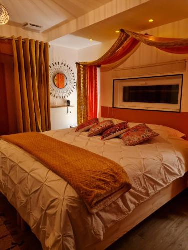 Schlafzimmer mit einem großen Bett und roten Vorhängen in der Unterkunft Home Gãyatri in Angé