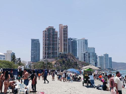 a group of people on a beach with tall buildings at Suite Hermosa ven descansa o trabaja El Rodadero Santa Marta in Gaira