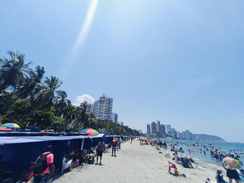 a crowd of people on a beach with umbrellas at Suite Hermosa ven descansa o trabaja El Rodadero 50m Playa in Gaira