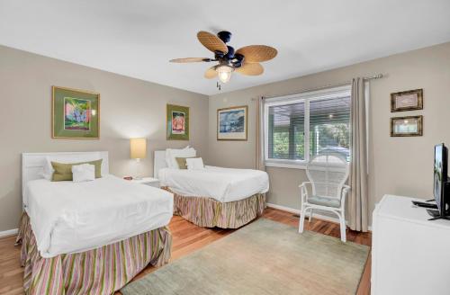 a bedroom with two beds and a ceiling fan at 3C Mariners Walk by AvantStay Beach Pool Access Enclosed Porch in Isle of Palms