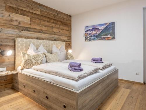 a bedroom with a large bed with a wooden wall at am Waldrand in Wörgl