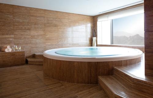 a large bathroom with a large tub with a window at Royal M Hotel Fujairah by Gewan in Fujairah