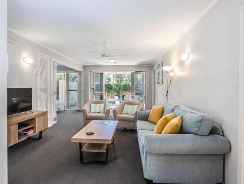 a living room with a couch and a table at Hastings Cove Holiday Apartments in Hastings Point