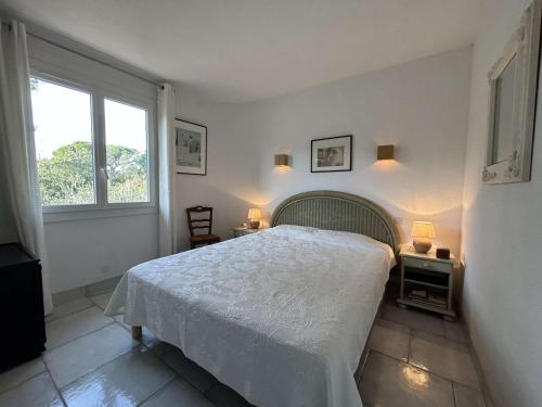 une chambre blanche avec un lit et une fenêtre dans l'établissement Sainte Maxime Sémaphore : Haut de Villa T4, Piscine, Terrasse, Clim, Proche Mer - FR-1-226-531, à Sainte-Maxime