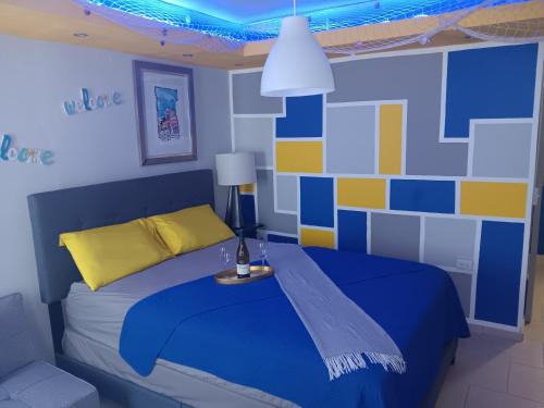 sypialnia z łóżkiem w kolorze niebieskim i żółtym w obiekcie Villamar2 w mieście Yeguada