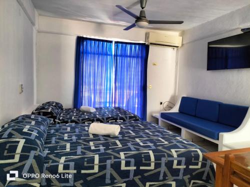 ein Schlafzimmer mit einem blauen Bett und einem blauen Sofa in der Unterkunft Olas Altas 534 Interior 4 in Puerto Vallarta