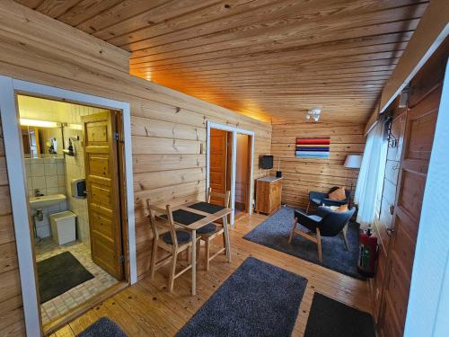 een kamer met een houten muur met een tafel en stoelen bij Luppoloma in Saariselkä