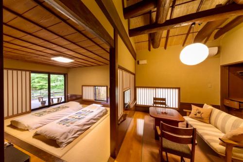 a bedroom with a bed and a couch in a room at Satonoyu Waraku 13 years or older in Minamioguni