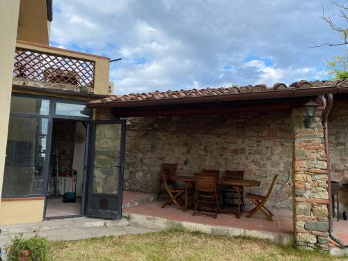 un patio avec une table et des chaises sous un toit dans l'établissement Impruneta Garden, à Impruneta