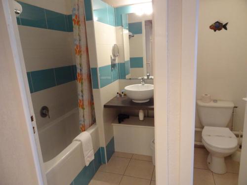 La salle de bains est pourvue de toilettes, d'un lavabo et d'une baignoire. dans l'établissement Hôtel Bellevue Cap d'Agde, au Cap d'Agde