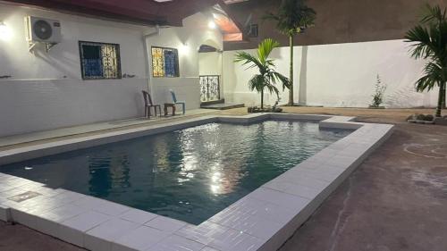 una piscina in un cortile con una casa di Dany Chantilly a Yaoundé