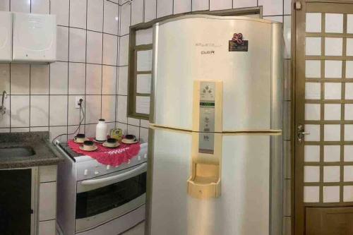 um frigorífico branco numa cozinha ao lado de um fogão em Casa de Férias 1purbana em Ribeirão Preto