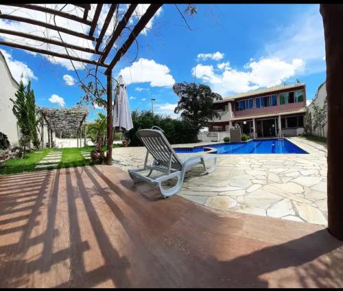a patio with a chair and a swimming pool at SITIO AMANHECER VERDE in Contagem