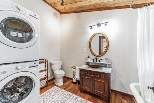 a bathroom with a washing machine and a washer and dryer at Comfortable home near wineries and hiking farmhouse in Hendersonville