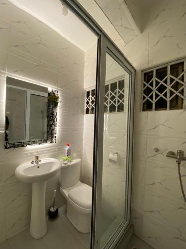 un bagno con lavandino, WC e doccia di Dabs Apartments a Accra