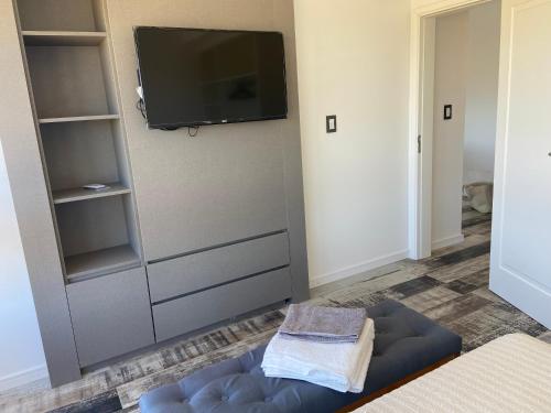 Costanera4 في سان نيكولاس دي لوس أرويوس: غرفة معيشة مع تلفزيون وأريكة زرقاء