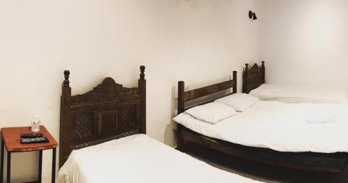 a room with two beds and a table with a night stand at Suítes Encanto de Minas in Tiradentes
