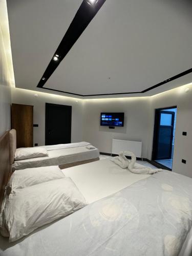 a bedroom with three beds and a flat screen tv at Antik Otel in Kayacık
