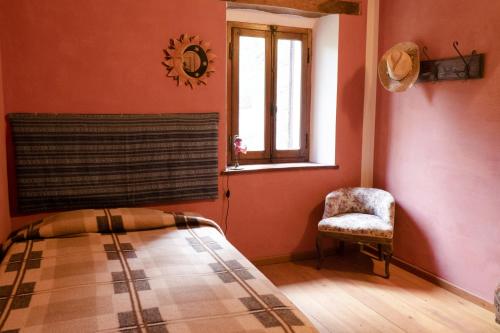 a bedroom with a bed and a chair and a window at B&B Ca'del Gallo in Novafeltria